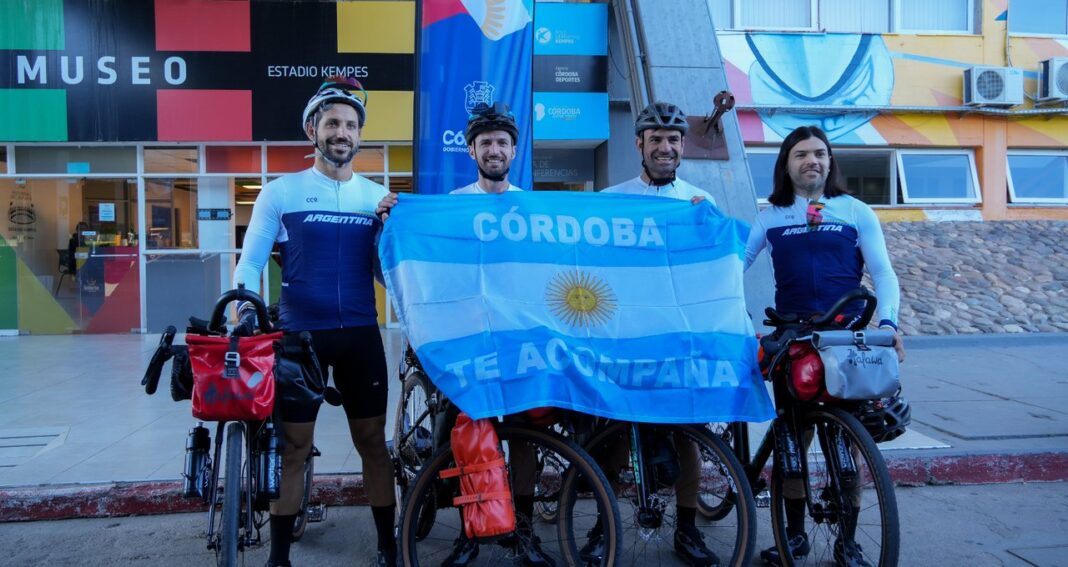 Cuatro ciclistas cordobeses posan con sus bicicletas frente al estadio Mario Alberto Kempes antes de iniciar su viaje al Mundial 2026