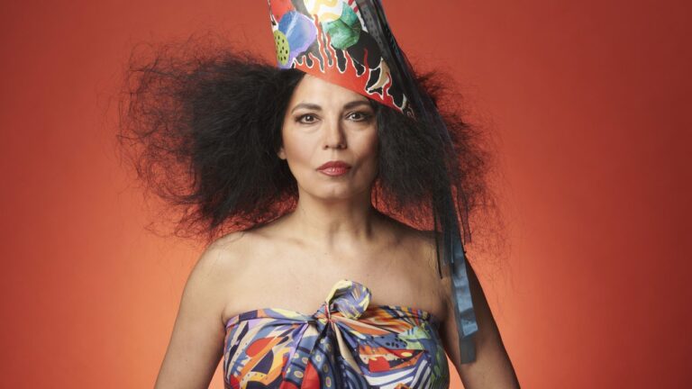 Charo Bogarín, artista con bonete guaraní, durante una presentación musical.