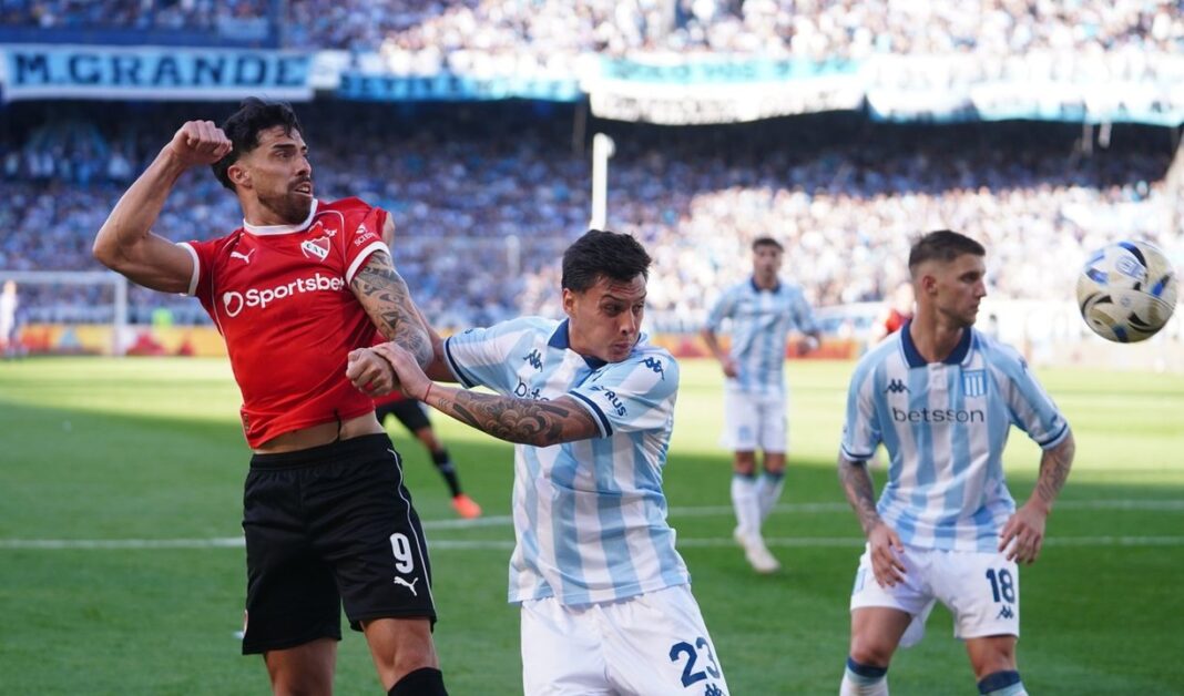 Escudos de Independiente y Racing Club a ambos lados de un balón de fútbol.