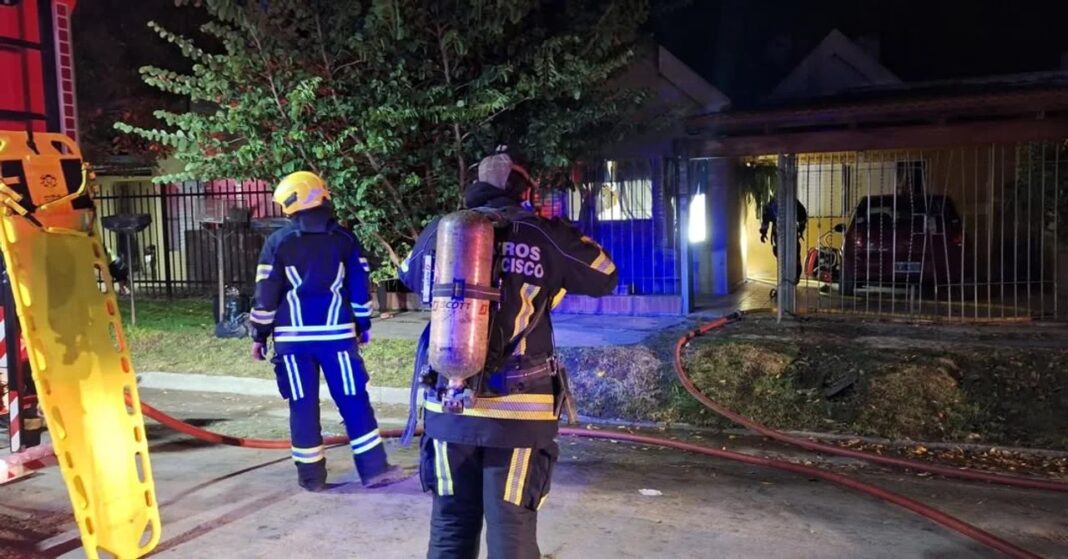 Bomberos y efectivos de seguridad trabajando en el perímetro de una vivienda tras un incendio en San Francisco, Córdoba.