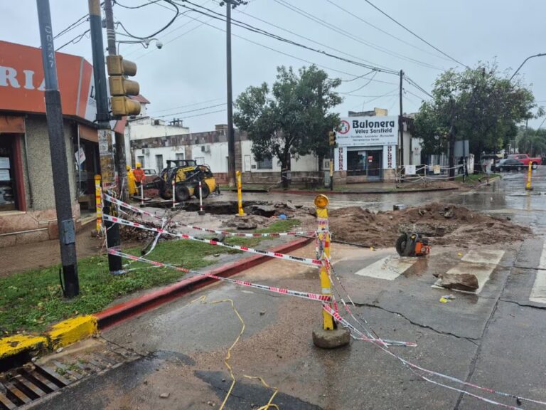 Socavón y pavimento colapsado en la avenida Vélez Sarsfield de Córdoba, con trabajadores en el lugar.