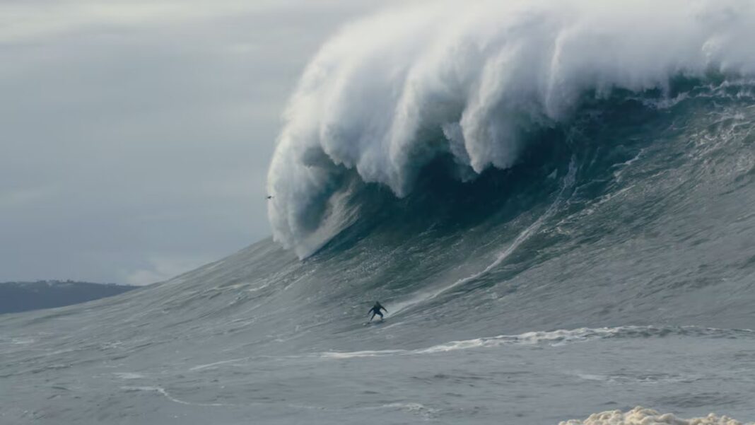 Sebastian Steudtner surfeando una ola gigante en la playa de Nazaré, Portugal.