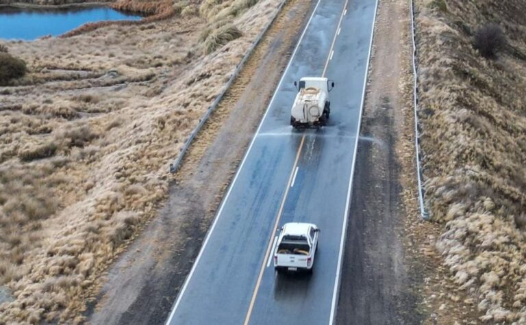 Vista de una ruta serrana cordobesa con nieve y señal de alerta meteorológica